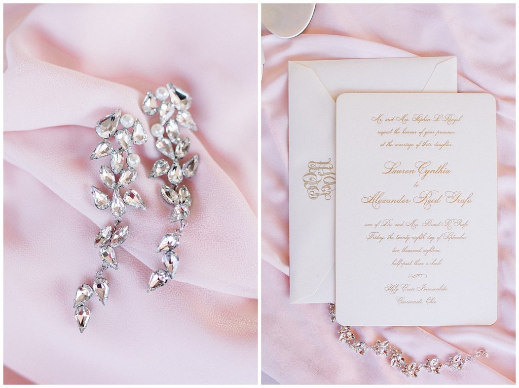 Close up details of large crystal earrings and wedding invitation