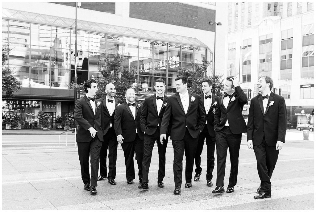 Groom and groomsmen walk across the street in downtown Cincinnati before the wedding