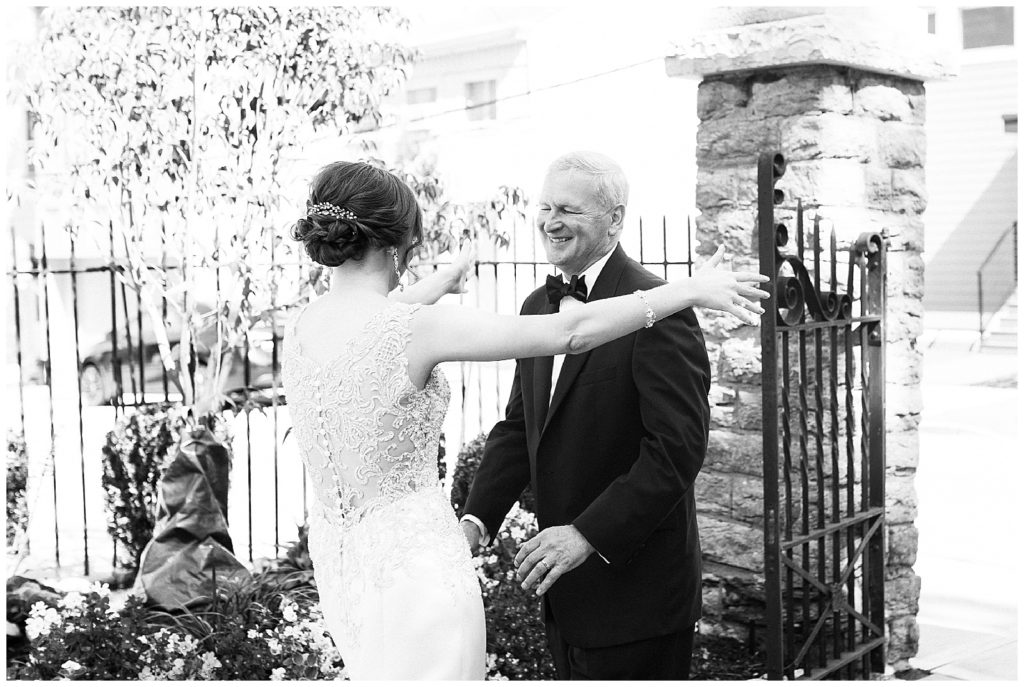 Bride and father smile and hug as they see each other for the first time on the wedding day