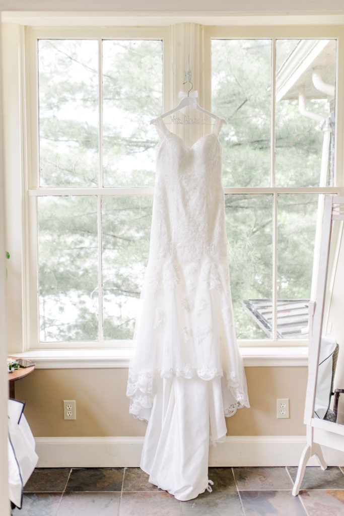 Wedding dress hangs in front of large windows at an Inn in Cincinnati, Ohio
