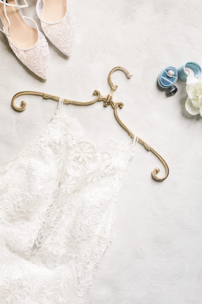 A wedding dress hangs on a brass antique hanger