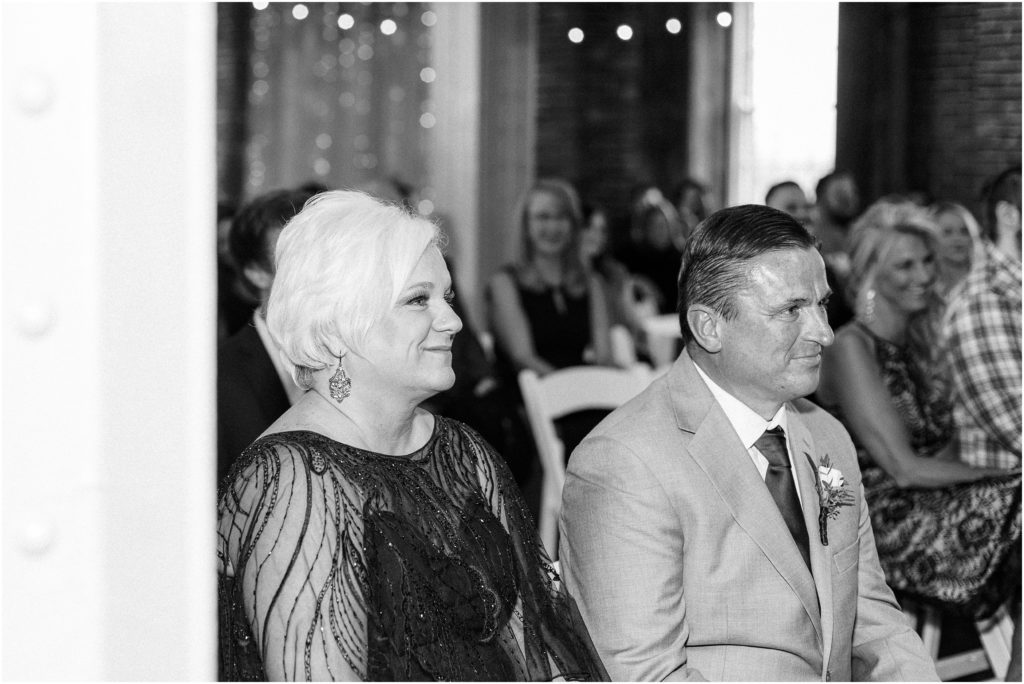 Black and white candid photo of parents during a wedding ceremony